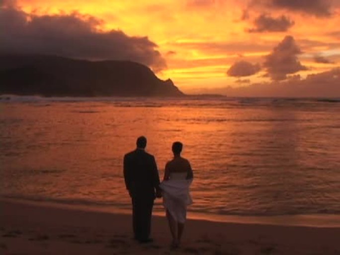 在考艾岛的哈纳莱伊湾，情侣们观看浪漫的夏威夷日落