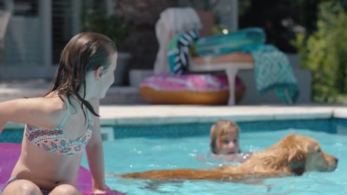 游泳池里快乐的小女孩漂浮在游泳管上，带着顽皮的狗和孩子们一起享受假期4k的暑假