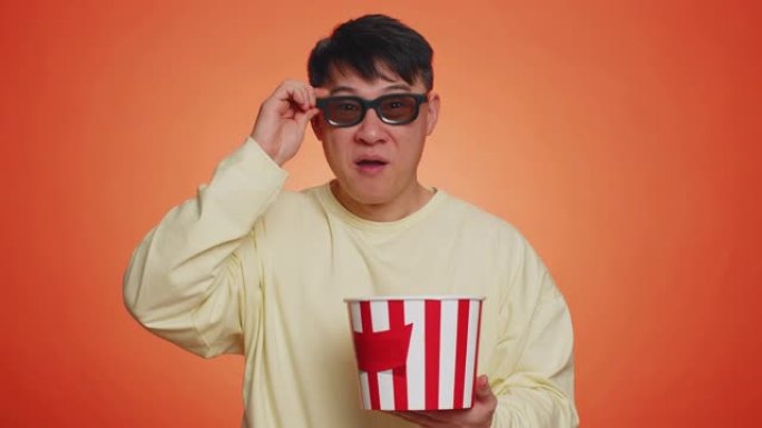 戴着3D眼镜的兴奋男子吃爆米花，看有趣的电视连续剧，体育游戏电影