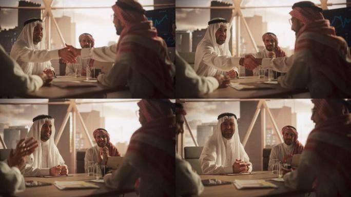 穆斯林商人在公司现代办公室完成业务交易。两个穿着传统服装的男人握手，庆祝成功的伙伴关系。沙特，阿联酋