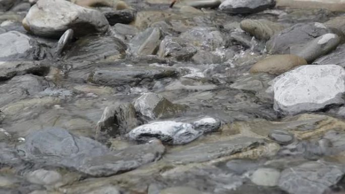 纯山溪流中的透明水在石头上流动