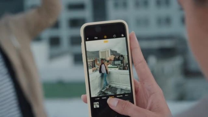 使用智能手机拍摄朋友摆姿势的照片的特写女人在日落时享受屋顶派对庆祝活动在社交媒体上分享城市疯狂周末