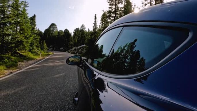 蓝色跑车在风景秀丽的山区路线上行驶