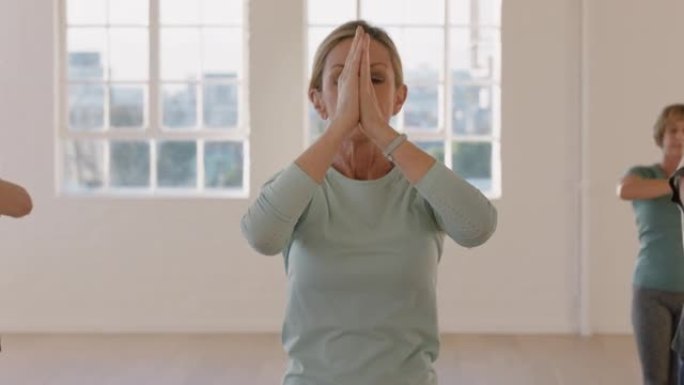 瑜伽课肖像成熟女性锻炼健康生活方式练习祈祷姿势享受工作室集体健身锻炼