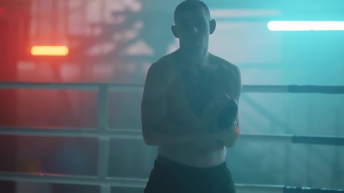 运动员高加索拳击手男子，纹身，在带bokeh灯的盒子里系上带子