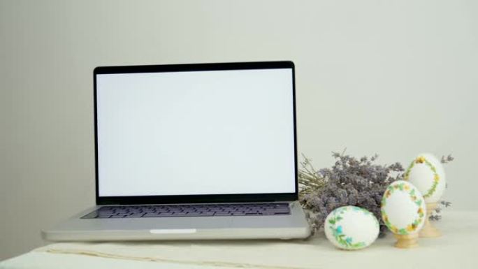 横幅广告明信片白色笔记本电脑显示器屏幕旁边的薰衣草三个刺绣彩蛋祝贺复活节的地方文字广告销售时间与家人