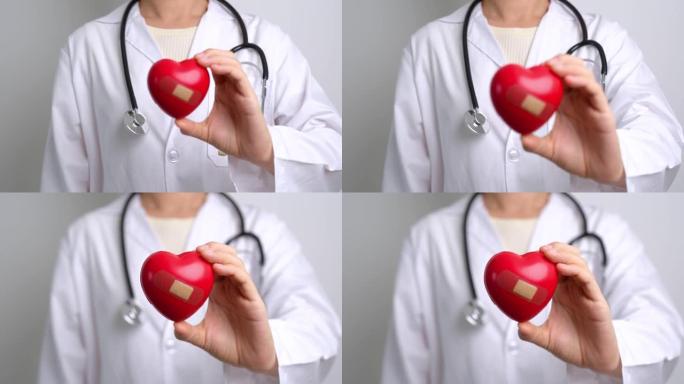 医生手握红色心形在医院。爱心，捐赠者，世界心脏日，世界卫生日，企业社会责任捐赠和保险概念
