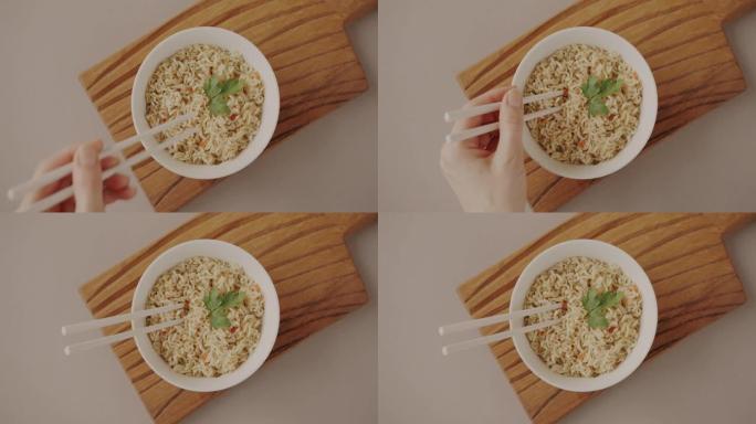一碗方便面的特写镜头和手把筷子放在盘子里准备吃的