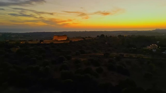 在日落时分，意大利西西里岛阿格里托的神庙山谷中被照亮的康科迪亚神庙的鸟瞰图