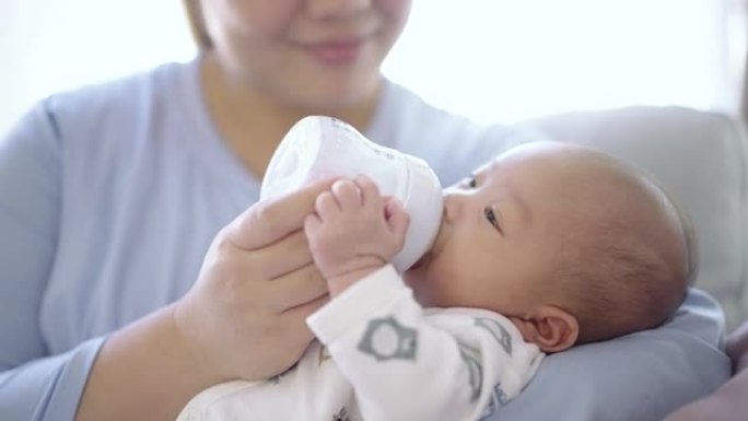 母亲用婴儿奶瓶喂养婴儿