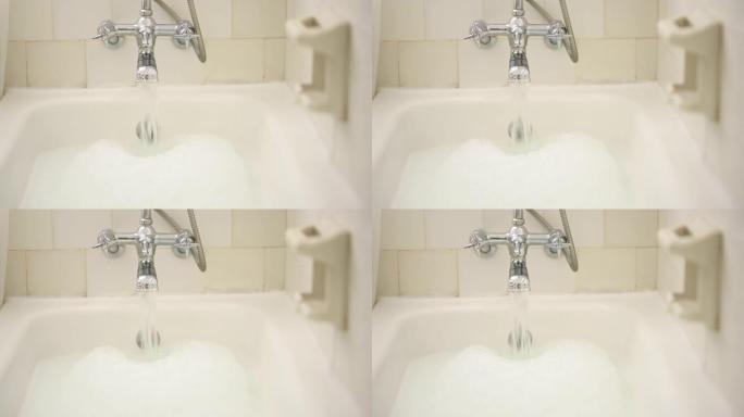 家庭浴室中的水、水龙头和泡泡浴，用于清洁、放松和洗涤，以实现自我护理和禅宗。镀铬水龙头，带有流动液体