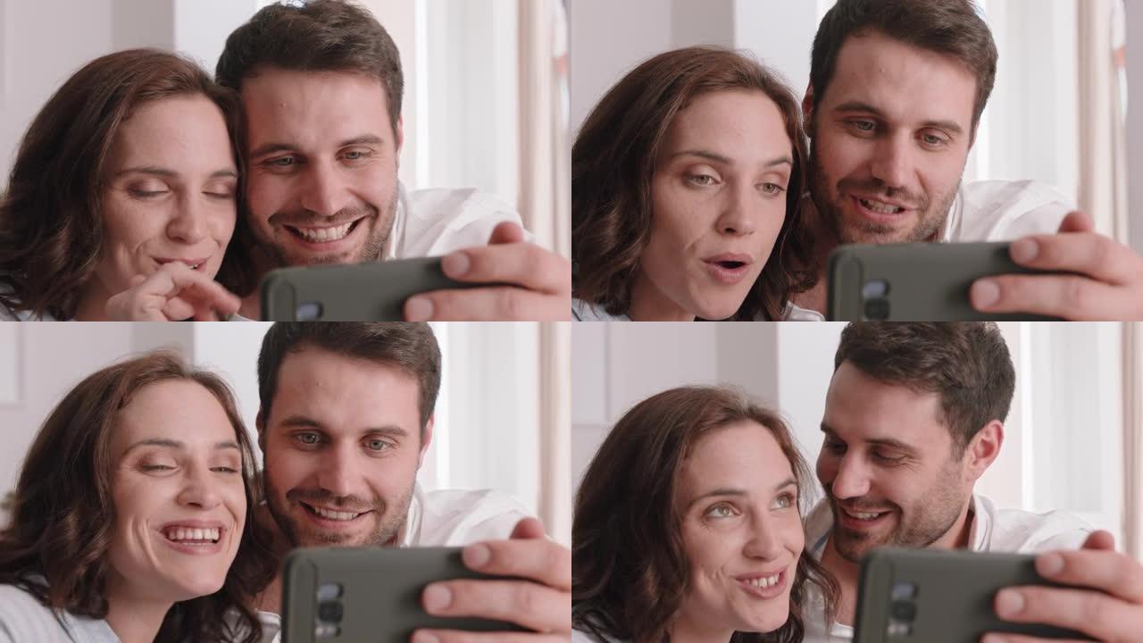 幸福的夫妻使用智能手机进行视频聊天与朋友聊天，微笑着兴奋地享受手机上的在线交流
