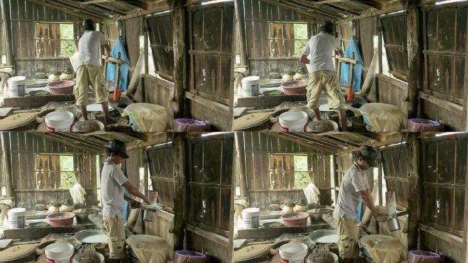 米粉生产商清洁木压机周围的面团残渣