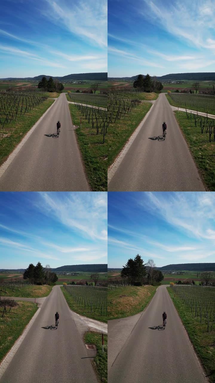 骑自行车的人在自行车上训练，在绿色的山丘上爬坡，垂直视频
