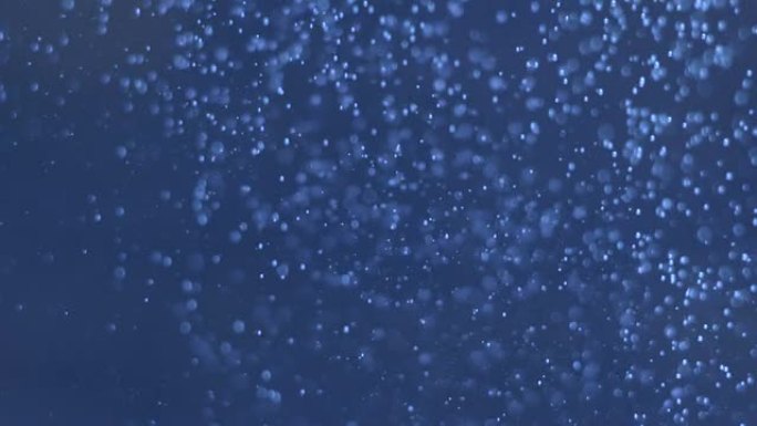 深蓝色水下海洋拍摄与混合墨水的气泡从左到右移动抽象背景