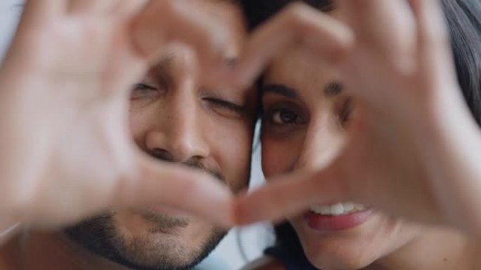 快乐的印度夫妇在情人节用手示意浪漫的承诺，享受爱情关系
