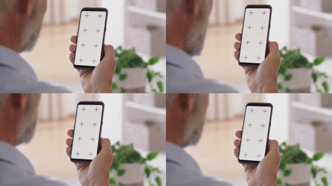 老人使用智能手机绿屏视频聊天惊讶地享受色度键显示垂直方向上的移动通信