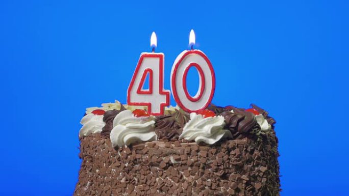 在美味的巧克力蛋糕上吹出40岁生日蜡烛，蓝屏