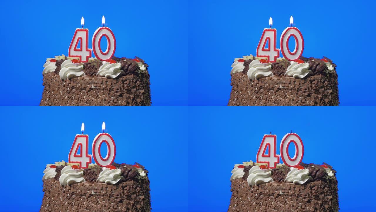在美味的巧克力蛋糕上吹出40岁生日蜡烛，蓝屏