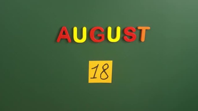 8月18日日历日用手在学校董事会上贴一张贴纸。18 8月日期。8月的第十八天。第18个日期编号。18
