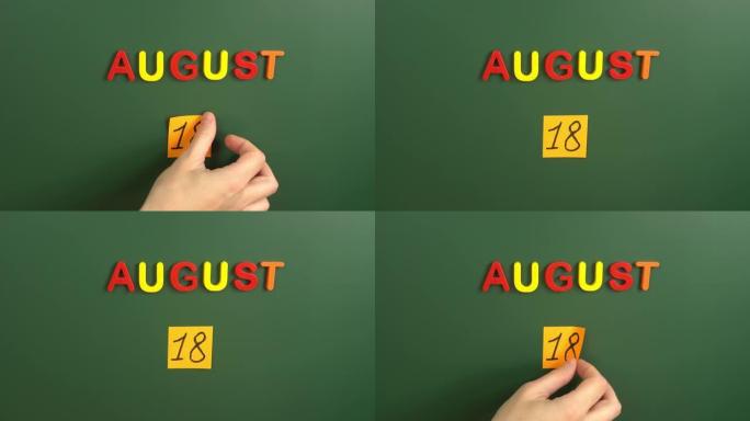 8月18日日历日用手在学校董事会上贴一张贴纸。18 8月日期。8月的第十八天。第18个日期编号。18