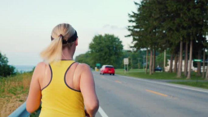 在典型的美国郊区，一名妇女沿着道路奔跑的后视图