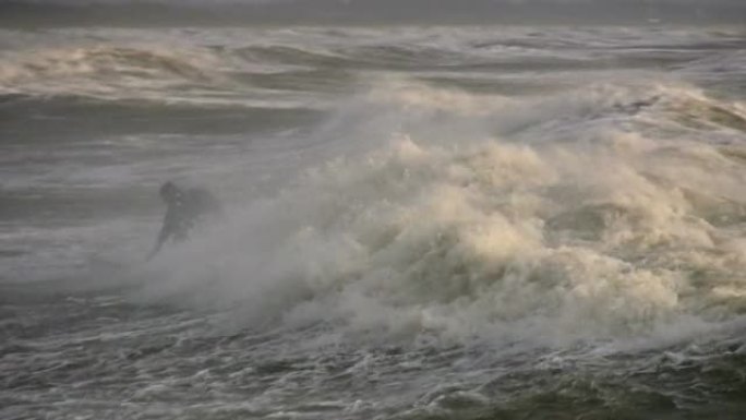 冲浪者试图赶上海浪。极端天气
