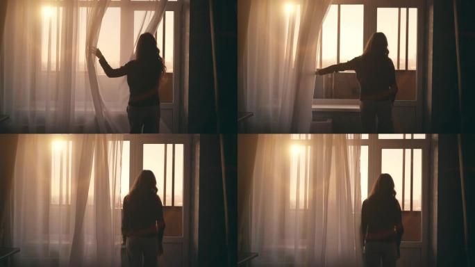 年轻女孩的剪影带着夕阳的光线走近窗户，打开窗帘