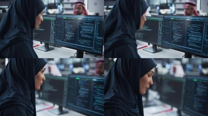 聪明的穆斯林工程师在一家科技公司办公室的电脑上工作。戴头巾的年轻阿拉伯妇女为创新的互联网服务提供商开