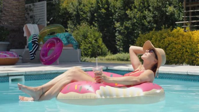 游泳池女子在游泳管上放松享受阳光明媚的假期，喝酒晒太阳玩得开心暑假4k镜头