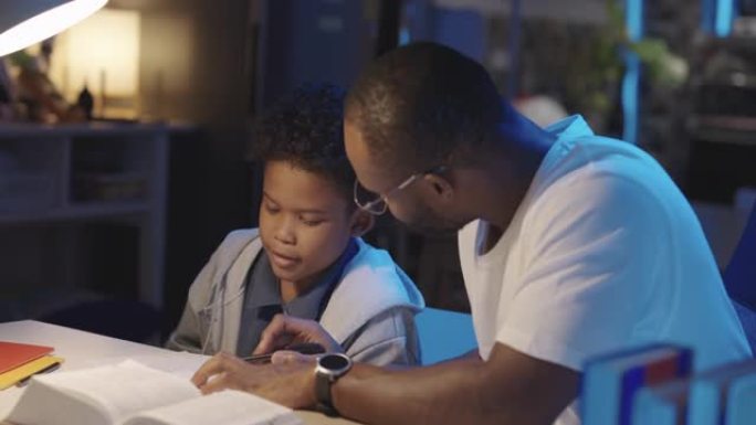 黑人家长在家帮孩子做作业。