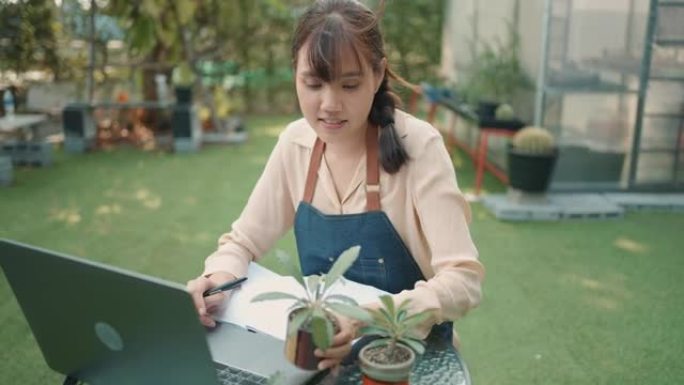 迷人的年轻亚洲女性花时间研究仙人掌。小企业。企业家。