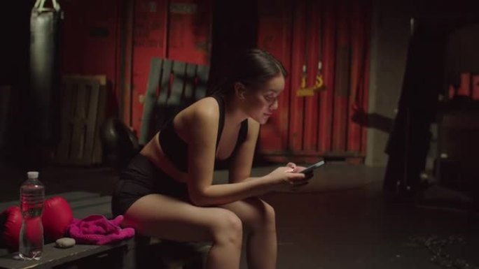 迷人的运动型适合亚洲女性的肖像，手机在健身房享受音乐