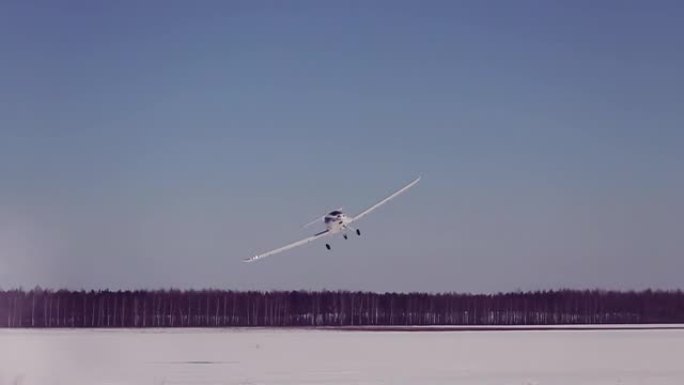 白色小型运动飞机飞越白雪皑皑的背景。
