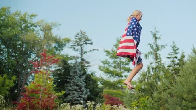 一名身披美国国旗的女子在肩上的蹦床上跳跃