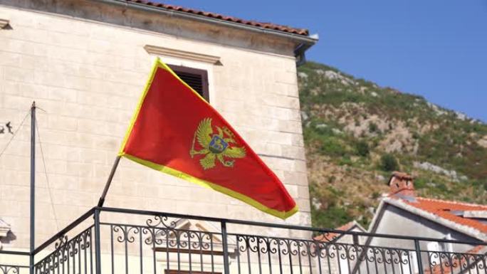 黑山国旗在一座古老的石头建筑的旗杆上随风飘扬