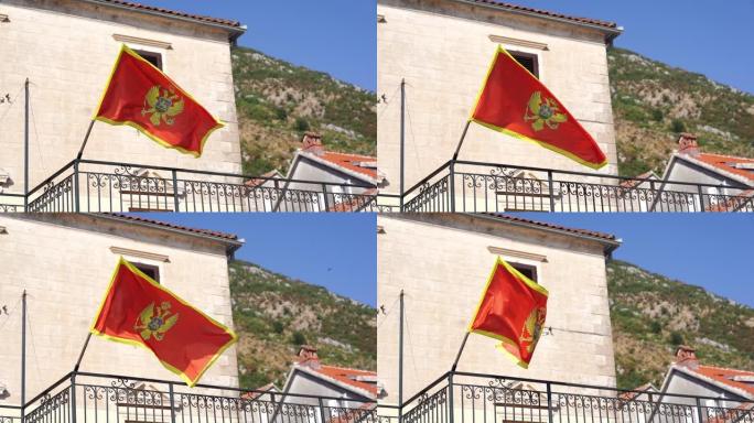 黑山国旗在一座古老的石头建筑的旗杆上随风飘扬
