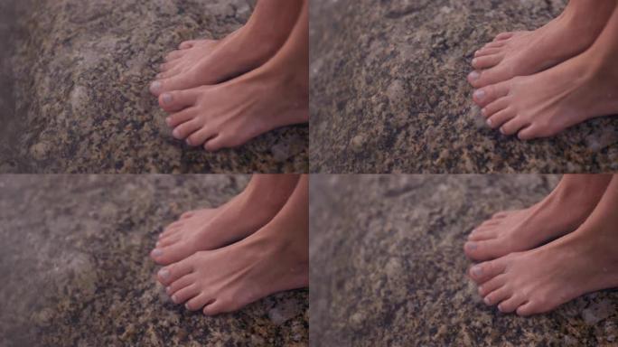 近距离脚浪轻溅赤脚女子站在海滩上享受水触摸脚趾清爽的海洋海滨度假