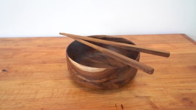 木桌上的木碗和筷子。空碗中国面条和木棍，亚洲中国日本泰国菜概念。