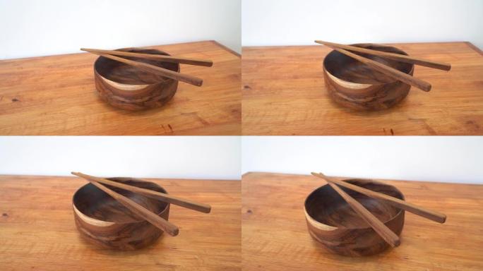 木桌上的木碗和筷子。空碗中国面条和木棍，亚洲中国日本泰国菜概念。