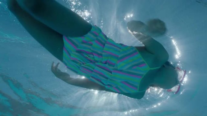小女孩穿着鳍状肢在游泳池游泳，享受夏日漂浮在清澈的水中游泳水下景观4k