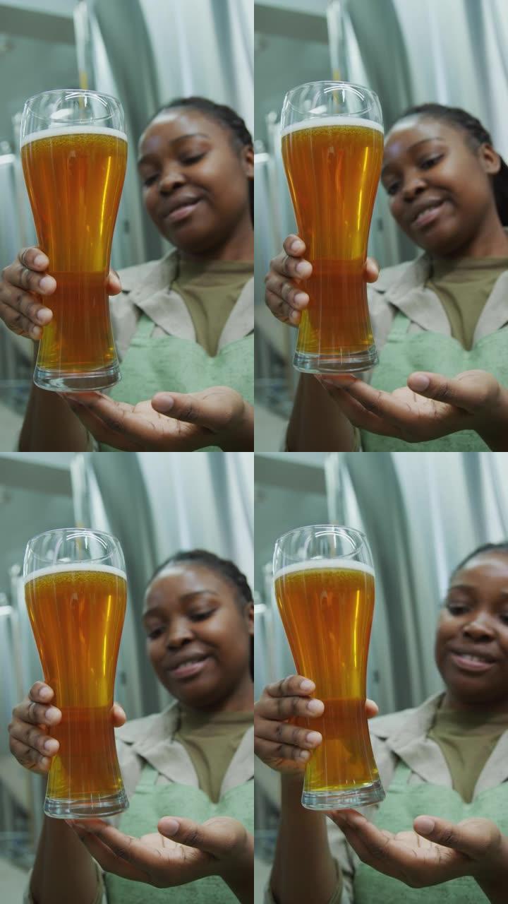 快乐的女性啤酒厂技术专家欣赏新型啤酒