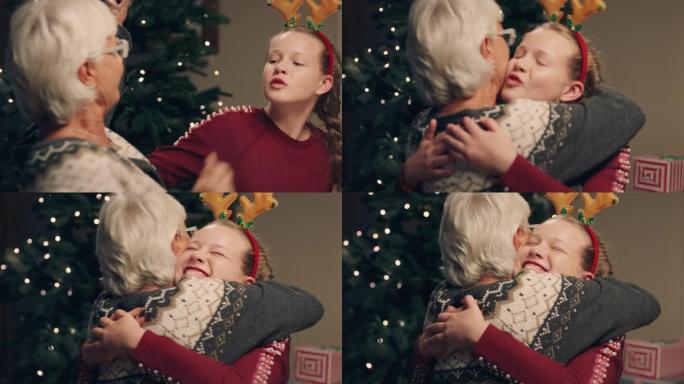 快乐的女孩在圣诞夜晚宴上拥抱祖母享受家庭庆祝活动，奶奶4k镜头