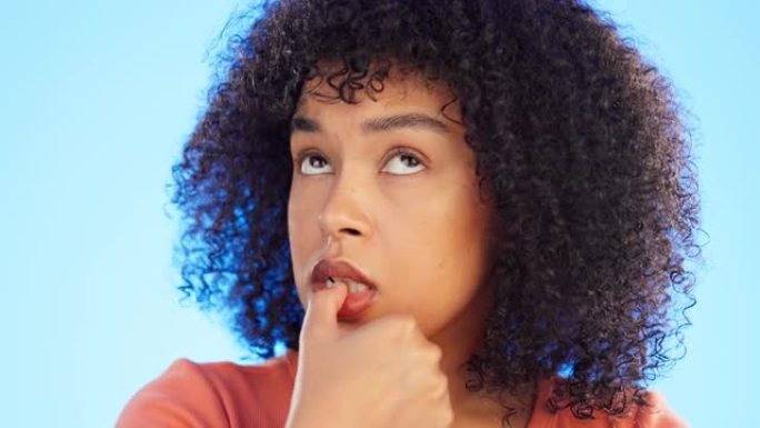 黑人妇女咬指甲，焦虑和恐惧与脸，精神卫生和神经孤立在蓝色背景。女性害怕，在工作室里思考危机或压力和担