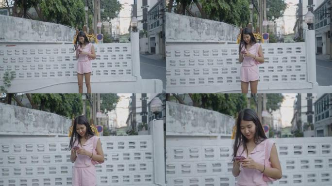 女孩站在街上打电话聊天，非常兴奋。相机放大了她，然后她看着相机，露出了甜美的微笑。