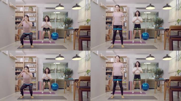 亚洲女子和姐姐用阻力带深蹲进行重量训练