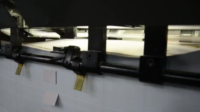 胶印机上的纸张传送到印刷车间的特写镜头。