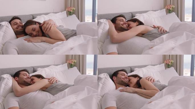 幸福的年轻夫妇躺在床上拥抱分享浪漫关系，在家享受亲密关系