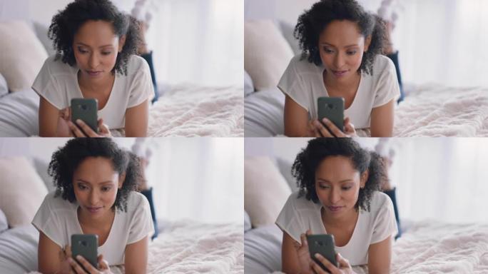 美女使用智能手机短信浏览社交媒体信息享受手机通信躺在家里的床上