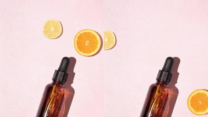生动的新鲜维生素c血清，带有棕色玻璃化妆品滴管瓶和柠檬和橙片，柔和的粉红色背景。天然明亮护肤概念。